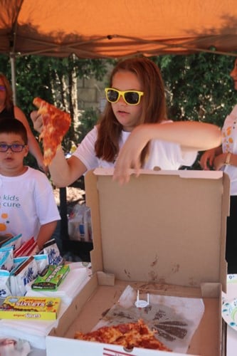 girl grabbing slice of pizza